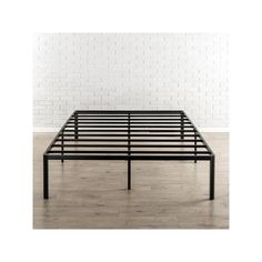 a black metal bed frame against a white brick wall