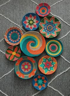 colorful bowls are arranged on the floor in a circle with different patterns and colors, as well as designs