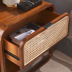 a wooden table with some books and a remote control on it's side shelf