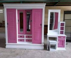 two white and pink dressers with mirrors on top of each other in a garage