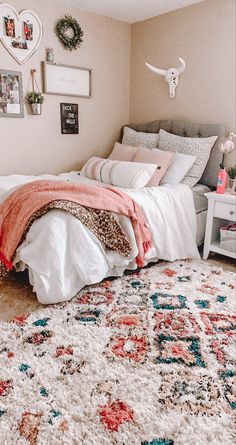 a bedroom with a bed, rugs and pictures on the wall above it is shown