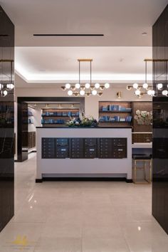 an empty library with lots of books on the shelves and lights hanging from the ceiling