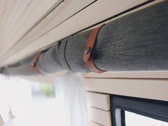 the back end of a bus with a window and curtains on it's side