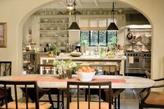 a kitchen with an archway leading into the dining room and kitchen area, along with several chairs