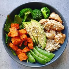 a blue bowl filled with rice, broccoli and sweet potato wedges next to green beans