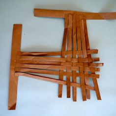 a piece of wood sitting on top of a white table covered in strips of paper