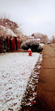 a red fire hydrant sitting on the side of a road covered in white snow