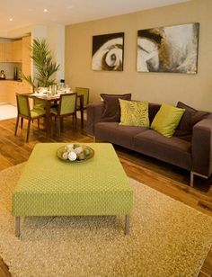 a living room filled with furniture next to a kitchen and dining room table on top of a hard wood floor