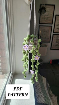 a crocheted hanging planter with flowers on it