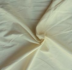 an unmade bed with white sheets on it