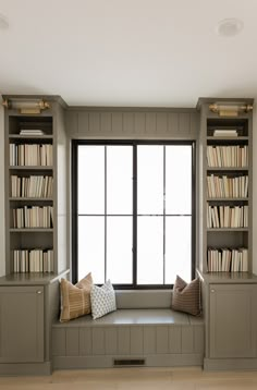 a window seat with bookshelves in front of it