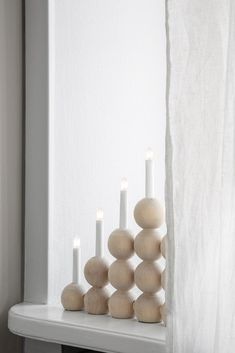 some white candles are sitting on a shelf