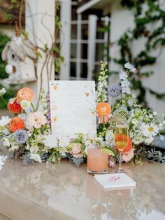 a table topped with flowers and candles next to a menu