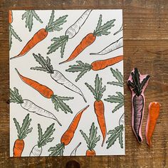 carrots and parsley on a white card with pink scissors next to it,