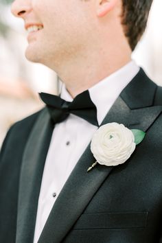 a man in a tuxedo with a white flower on it's lapel