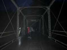 two people walking across a bridge at night