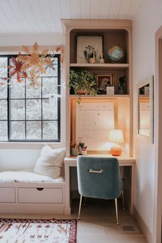 a room with a window, desk and chair in it's corner area next to a rug