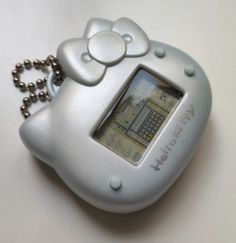 an electronic device with a hello kitty keychain attached to it's side