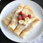 a plate with some pancakes and raspberries on it