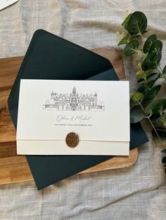 an envelope with a stamp on it sitting next to some green leaves and a wooden cutting board