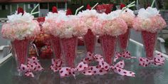 pink and white flowers in vases with polka dots on the bottom, sitting on a table