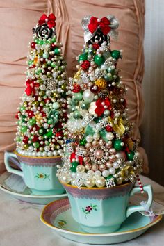 two small christmas trees in tea cups on a table