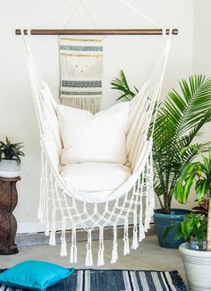 a white hammock chair sitting next to potted plants