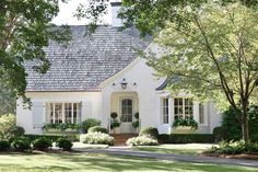 a white house surrounded by trees and bushes