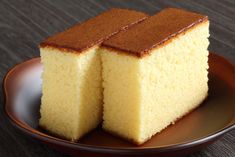 two pieces of yellow cake on a brown plate