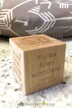 a wooden block with the name and date engraved on it sitting on a marble surface