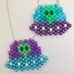 two necklaces made out of beads on a white surface