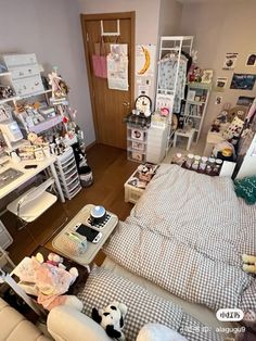 a room with a bed, desk and shelves full of stuff on the wall next to it