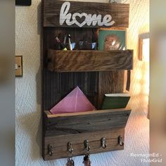 a wooden shelf with some items on it and the word home above it is hanging from the wall