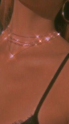 a close up of a woman wearing a bra with beads on her neck and necklace