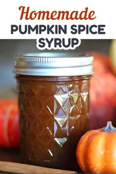 homemade pumpkin spice syrup in a glass jar next to apples and cinnamon sticks with text overlay that reads homemade pumpkin spice syrup