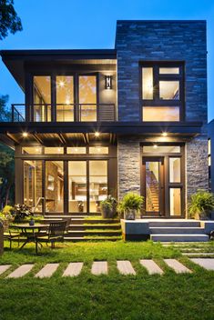 a large house with lots of windows and steps leading up to the front door at night