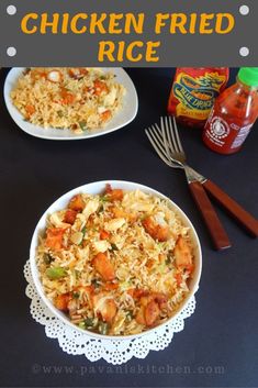 chicken fried rice in a white bowl on top of a table next to a fork and spoon