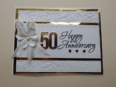 a 50th anniversary card with a bow on the front and white ribbon at the bottom