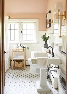 a bathroom with pink walls and white tile on the floor is pictured in this image