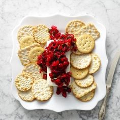 a white plate topped with crackers and red flowers