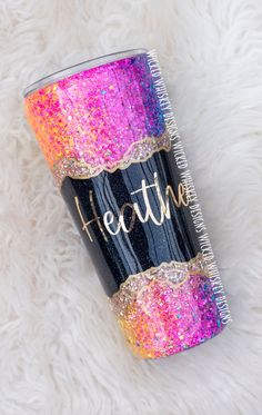 a black and pink glitter tumbler with the words breathe on it sitting on a white furnishing