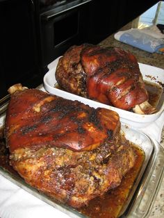 two trays filled with meat sitting on top of a counter