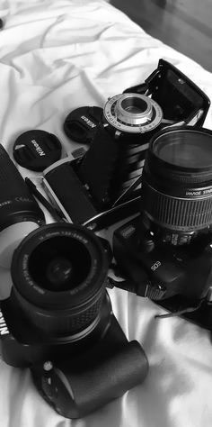 black and white photograph of camera equipment on bed