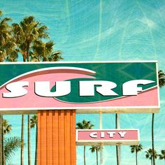 surf city sign with palm trees in the background