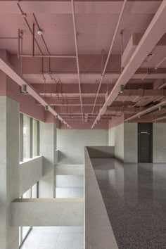 an empty room with pink paint on the ceiling and concrete flooring in front of it