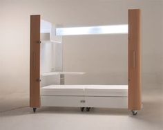 an empty white room with some shelves and drawers on wheels in front of the door