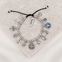 Glory Saints & Angels Bracelet silver tone saint medal charm bracelet on black slip knot cording with blessed charm tag Silver Spiritual Rosary Bracelet For Blessing, Spiritual Rosary Bracelet With Miraculous Medal, Adjustable Spiritual Jewelry With Miraculous Medal, Adjustable Spiritual Bracelets With Miraculous Medal, Anthony Hope, Angel Protection, Blessing Bracelet, Angel Bracelet, The Glory Of God