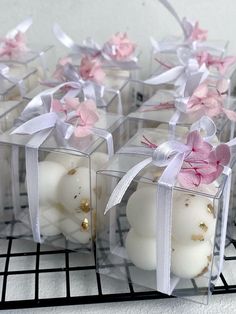 small candles are wrapped in clear boxes with pink and white flowers