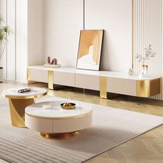 a living room with white furniture and gold accents on the table, along with a rug