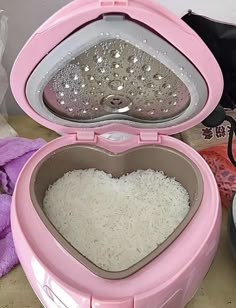 a pink heart shaped container filled with rice